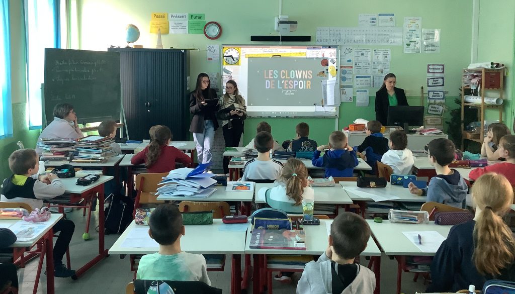 lycéens en classe devant écoliers